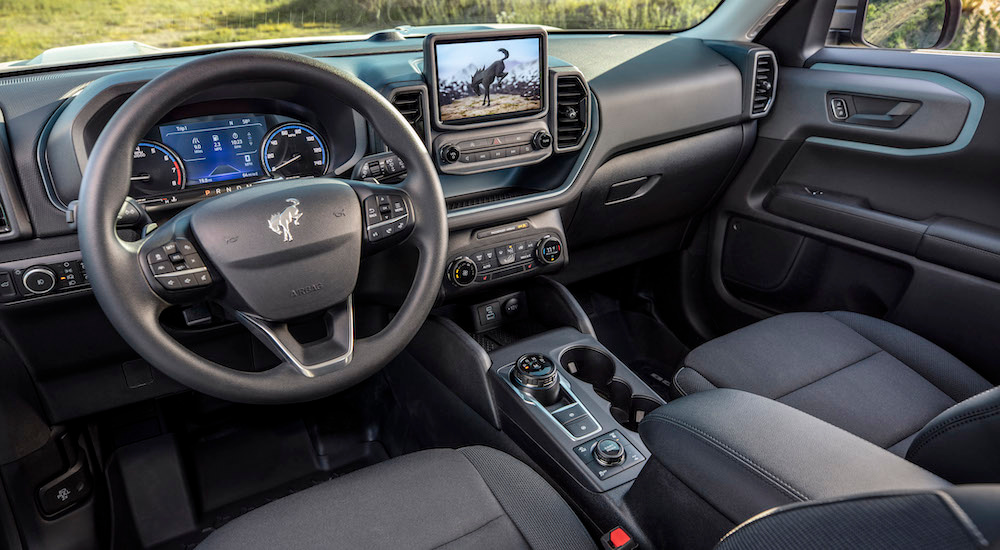 The black interior of a 2025 Ford Bronco Sport is shown from the driver's seat.