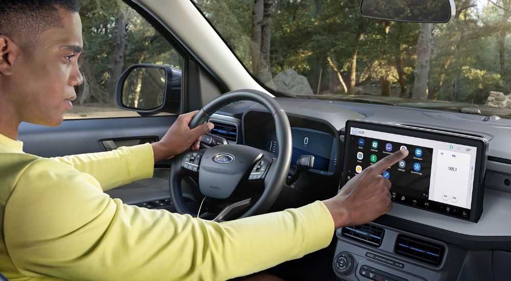 A driver using the infotainment screen in a 2025 Ford Maverick.