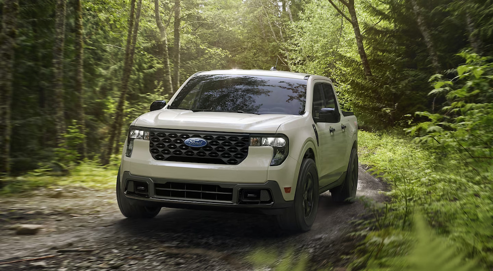 A tan 2025 Ford Maverick XLT off-roading in the woods.