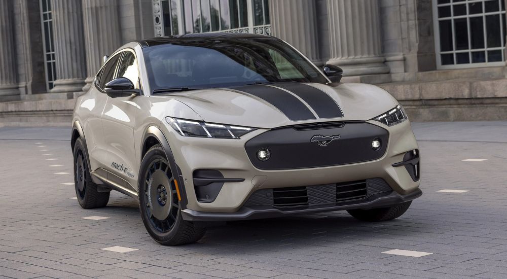 A tan and black 2025 Ford Mustang Mach-E Rally parked outside a Ford dealer near Barrington.