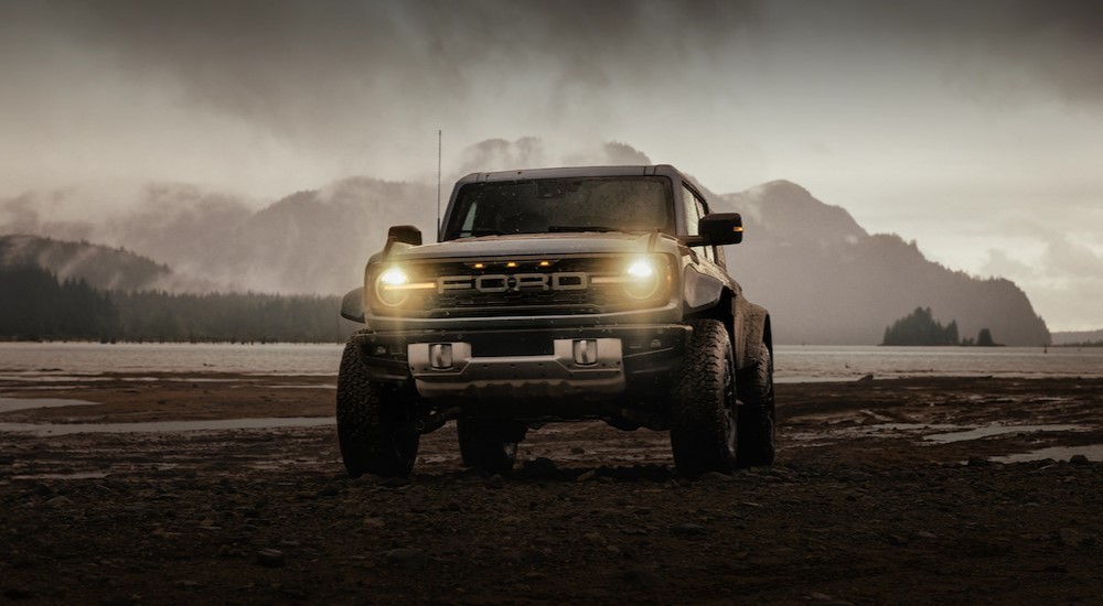 A green 2025 Ford Bronco parked with its lights on.