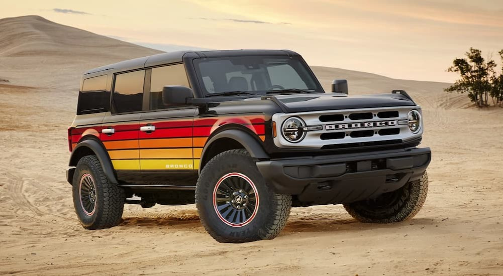 A multi-colored 2025 Ford Bronco parked off-road.