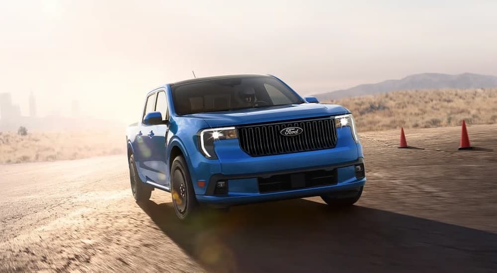 A blue 2025 Ford Maverick Lobo driving near safety cones.