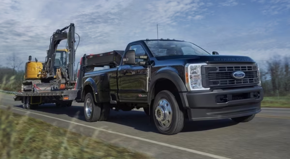 Black 2026 Ford F-450 towing an excavator
