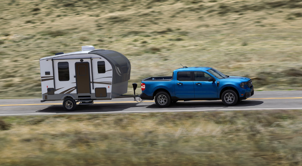 Blue 2026 Ford Maverick XLT towing a camper