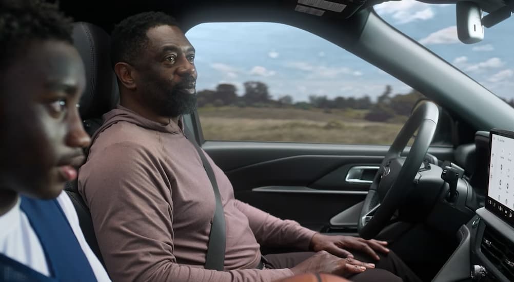 Two people driving in a 2026 Ford Explorer.