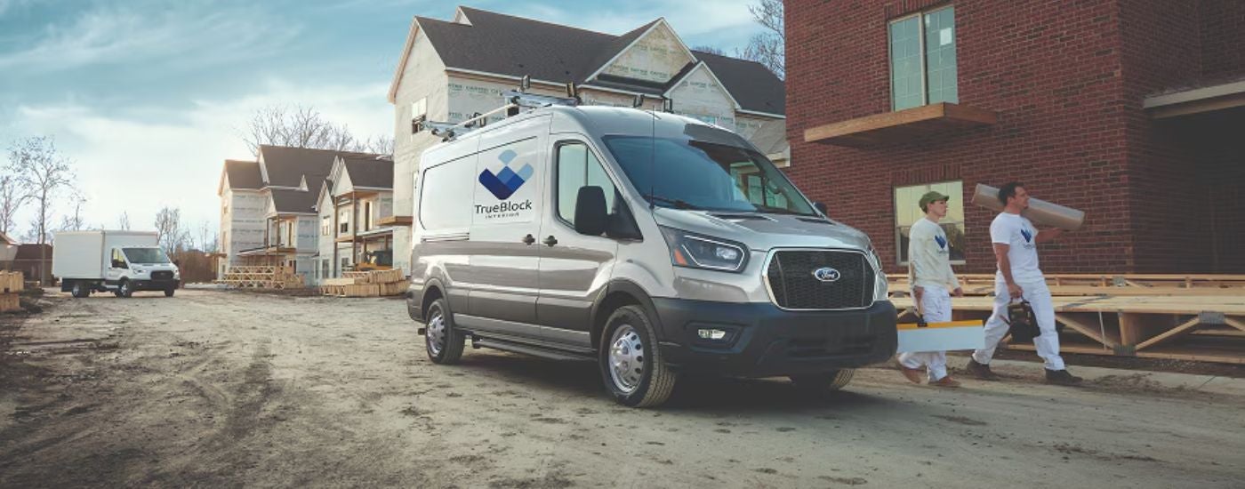 A gray 2026 Ford Transit shown parked at a construction site.