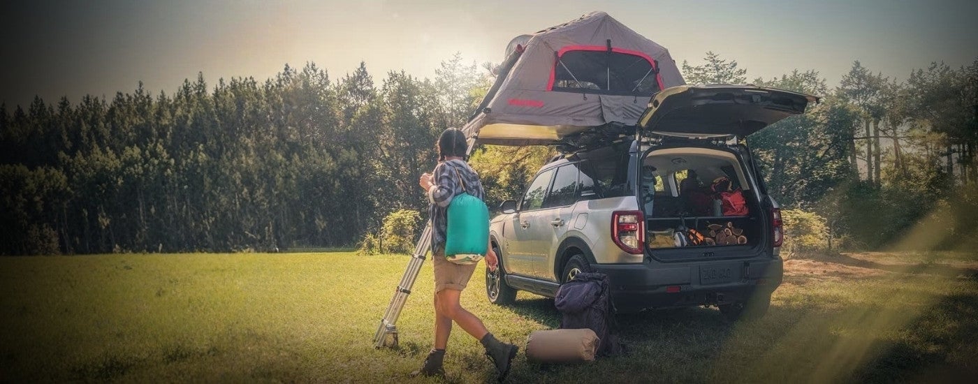 Person camping near a silver 2023 Ford Bronco Sport