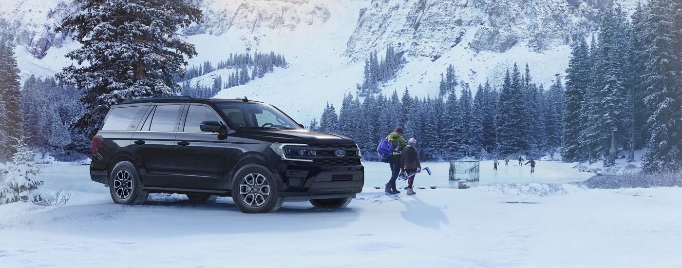 A black 2023 Ford Expedition XL STX parked in a snowy forest and angled right.