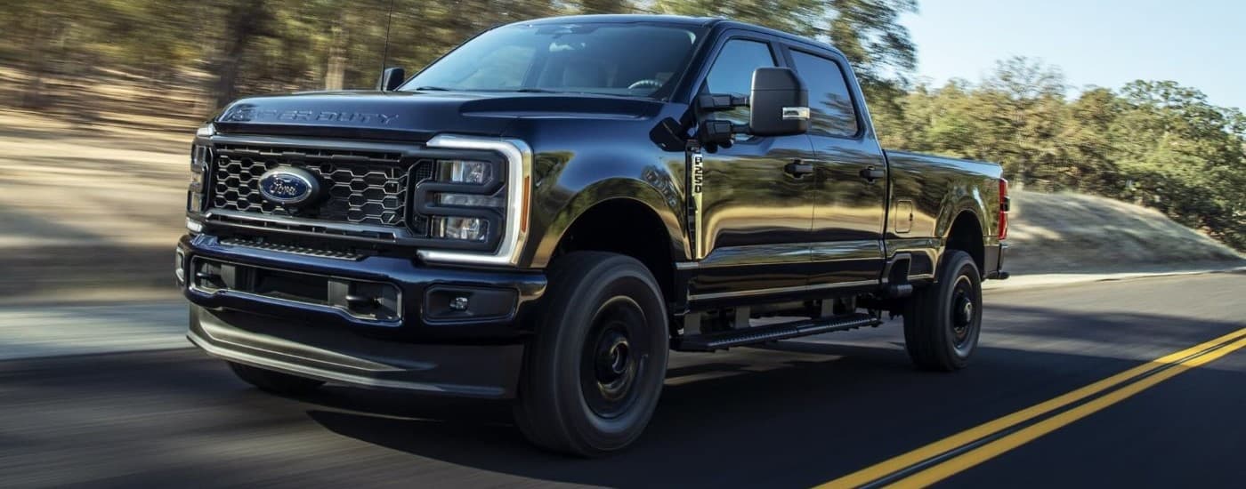 Black 2026 Ford F-250 XL STX driving down a road.