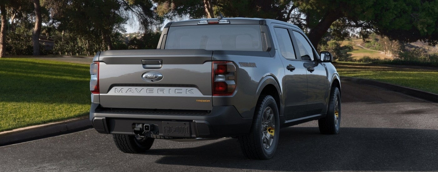 Grey 2024 Ford Maverick XLT Tremor driving on a tree-lined road