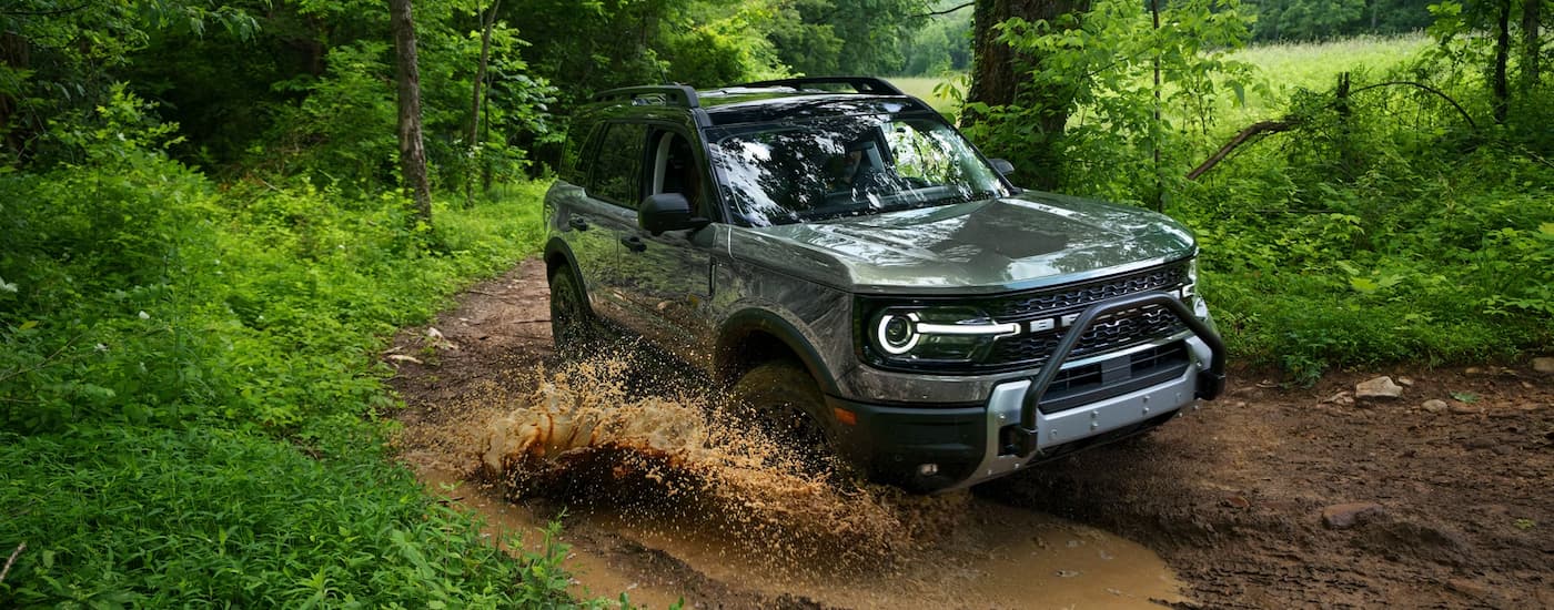 Grey 2026 Ford Bronco Sport driving through a muddy puddle