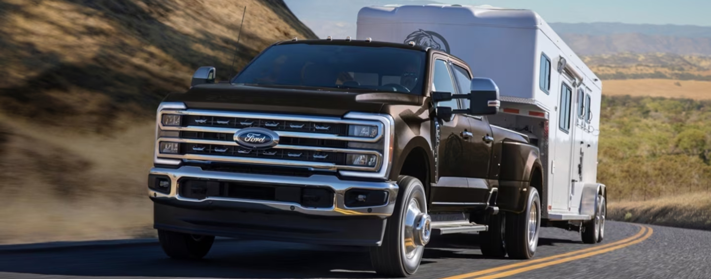 Brown 2026 Ford F-350 towing a camper up a hill
