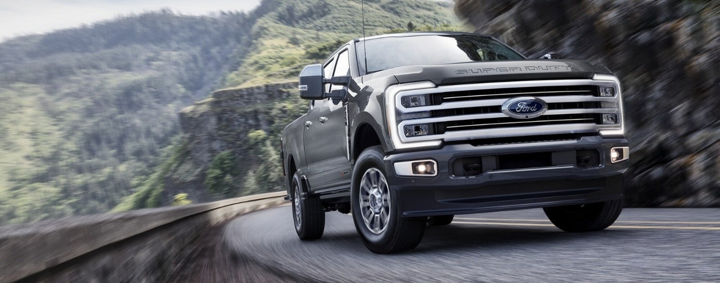 Grey 2026 Ford F-350 Platinum Plus driving around a bend.