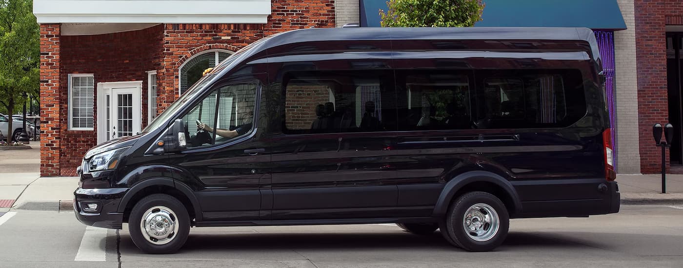 Side of a black 2025 Ford Transit stopped at a crosswalk.