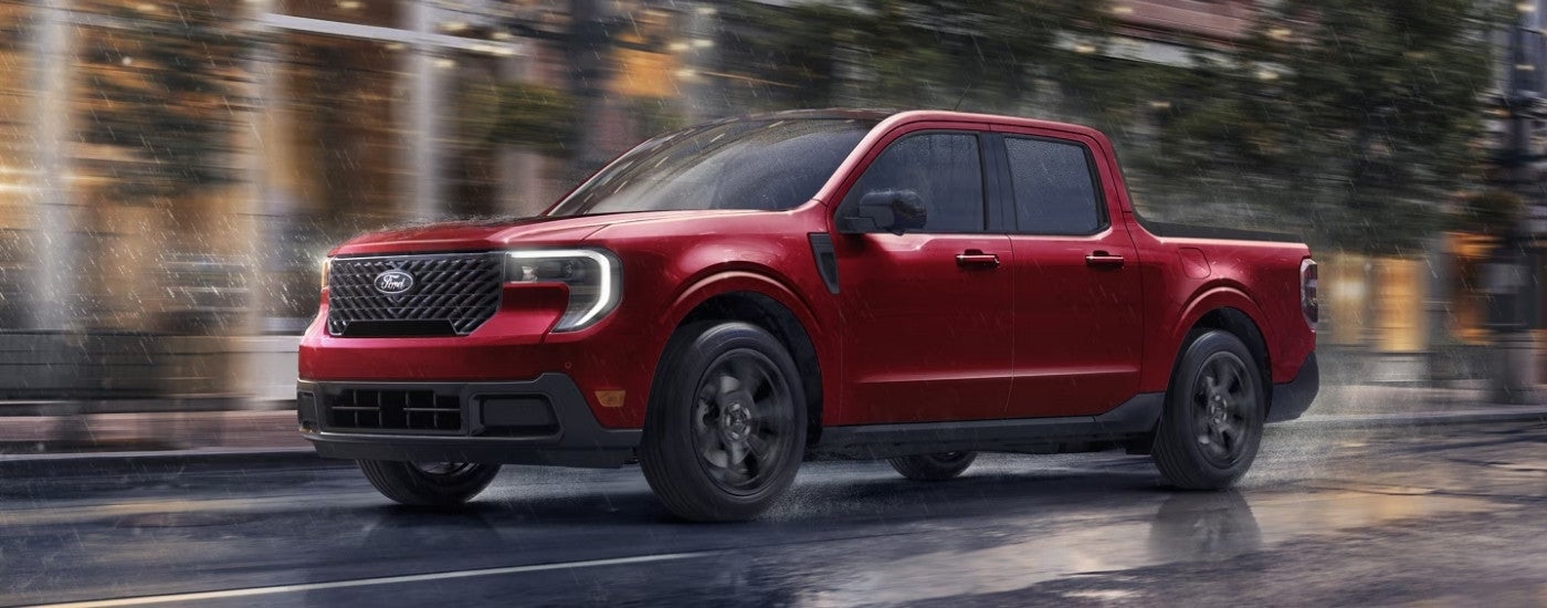 A red 2025 Ford Maverick driving on a rainy street.