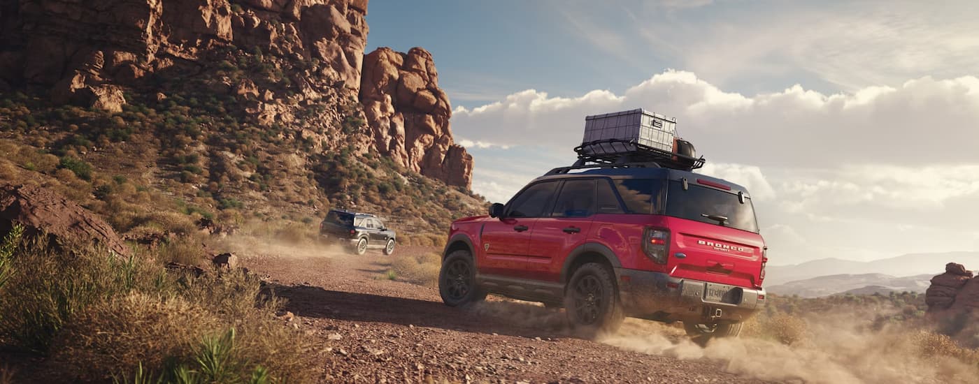 Red 2025 Ford Bronco Sport driving on a dusty dirt road