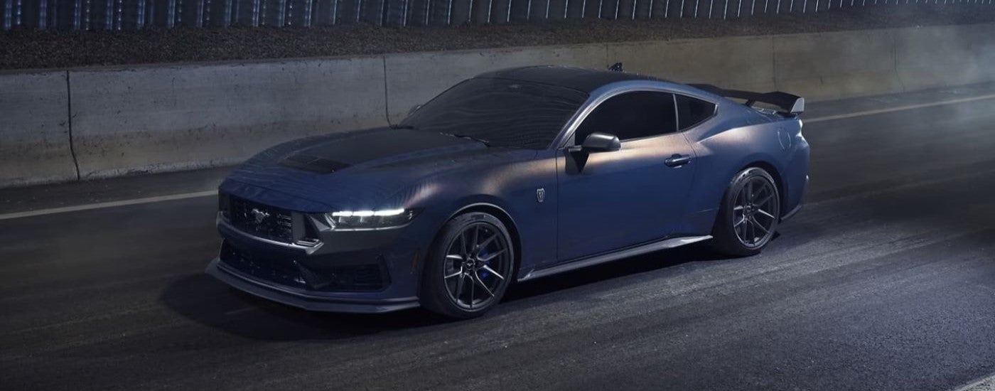 A blue 2024 Ford Mustang Dark Horse driving through a tunnel.