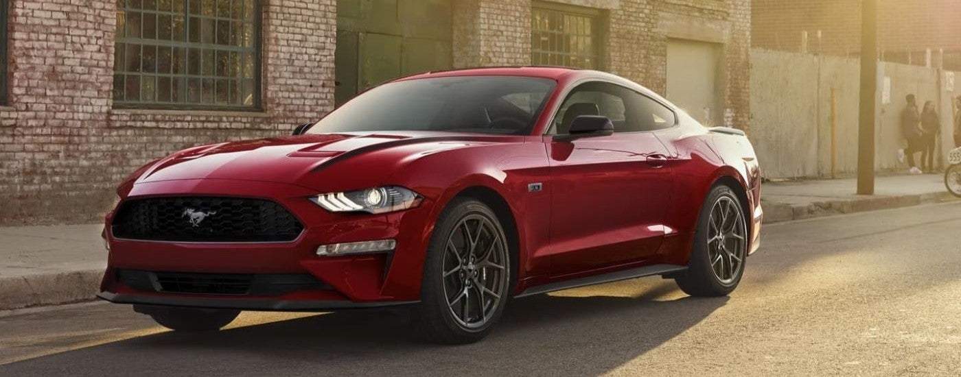 A red 2022 Ford Mustang is parked in an alleyway.