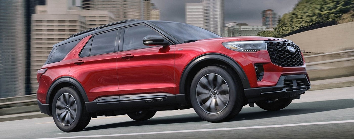 A red 2025 Ford Explorer ST-Line driving in a city